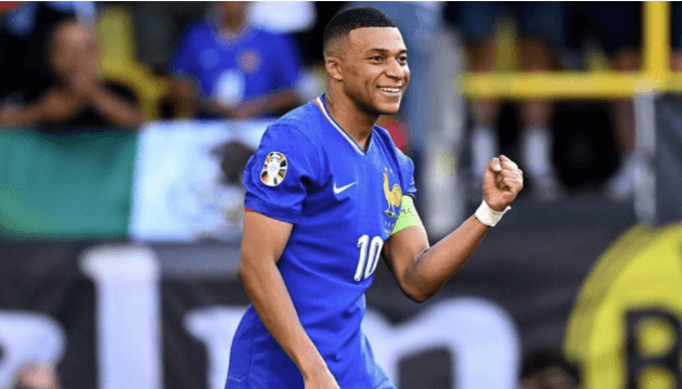 Kylian Mbappe pumps his first and smiles to the crowd while playing for France in file photo.