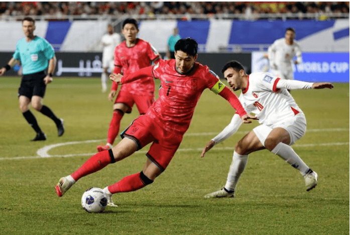 Forward Son Heung-min (middle) tries to kick the ball past a defender (right) while playing for the South Korea mens national team in file photo. FIFA World Cup 2026 Profile: Son Heung-min