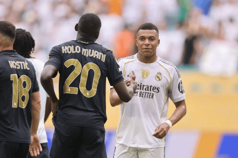 French football star Kylian Mbappe (white, right) shakes an opponent's hard in the pitch as he made his return for Real Madrid against Juventus at their FIFA Club World Cup round-of-16 match on Tuesday.  Madrid vs Juventus sees Los Blancos in Club World Cup quarters