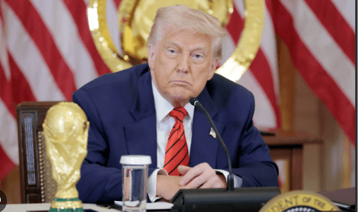 US President Donald Trump listens at a news conference weith the FIFA title i 