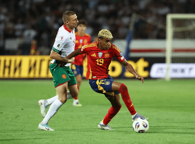 Lamine Yamal of Spain (19, right) controls the ball against Bulgaria's Anton Nedyalkov (left) in their September 2025 World Cup UEFA qualifying match.