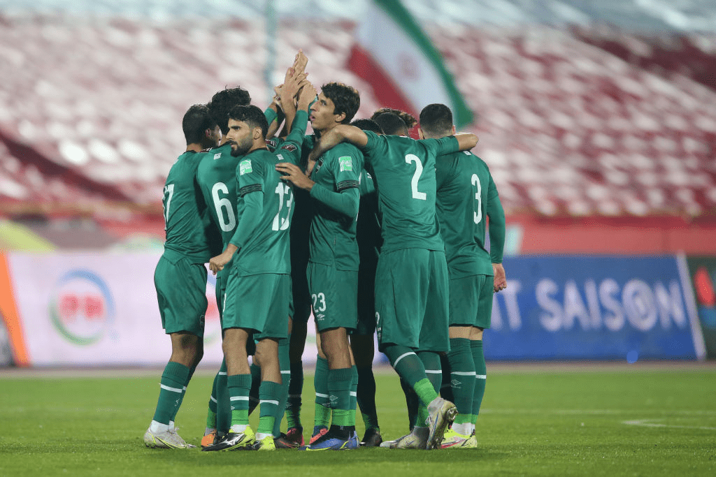 Iraqi players gather in a huddle during a break in a match.