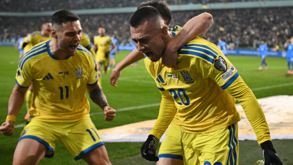 Oleksandr Zubkov (20, right) celebrates as he was cheered on by his teammates after giving Ukraine its first goal vs Iceland.